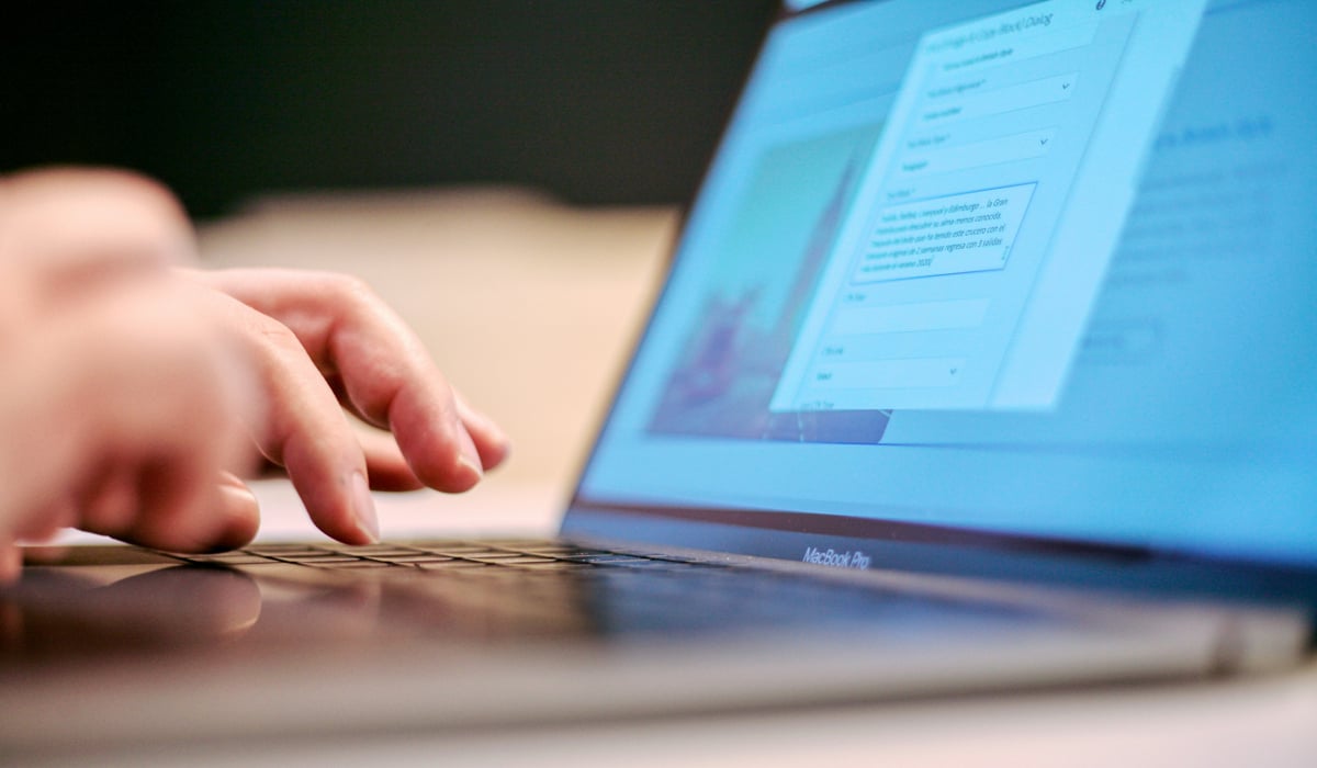 A close up of a person typing on a laptop.
