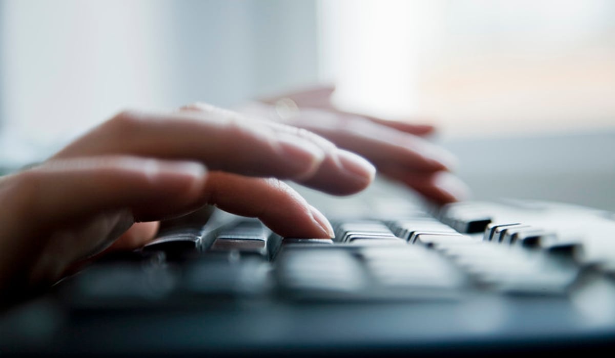 A close up of a person typing on a keyboard.